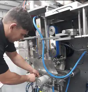 Industrial technician performing preventive maintenance on packaging machinery